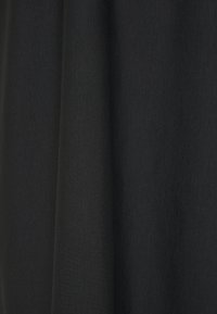 Rideau ou tissu noir avec des plis verticaux doux et une texture lisse.