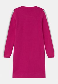 Fuchsia stickad klänning med lång ärm. Har grå ränder längs ärmarna. Enkel rund halsringning och avslappnad passform.