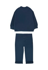 Marineblauwe sweatshirt met lange mouwen en een afgeronde zoom, gecombineerd met bijpassende broeken met opgerolde boorden en een achterzak. Zachte stoftextuur.