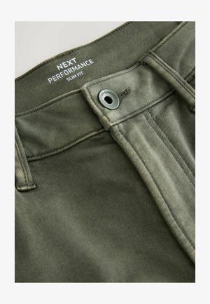 Pantaloni slim-fit in tessuto verde oliva. Presentano una chiusura con bottone, fronte piatto e dettagli cuciti lungo la vita e le tasche.