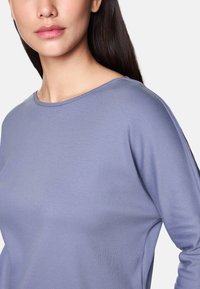 Helllila Langarmshirt aus glattem, weichem Stoff mit rundem Halsausschnitt und subtiler Rippstruktur, bietet eine lockere Passform.