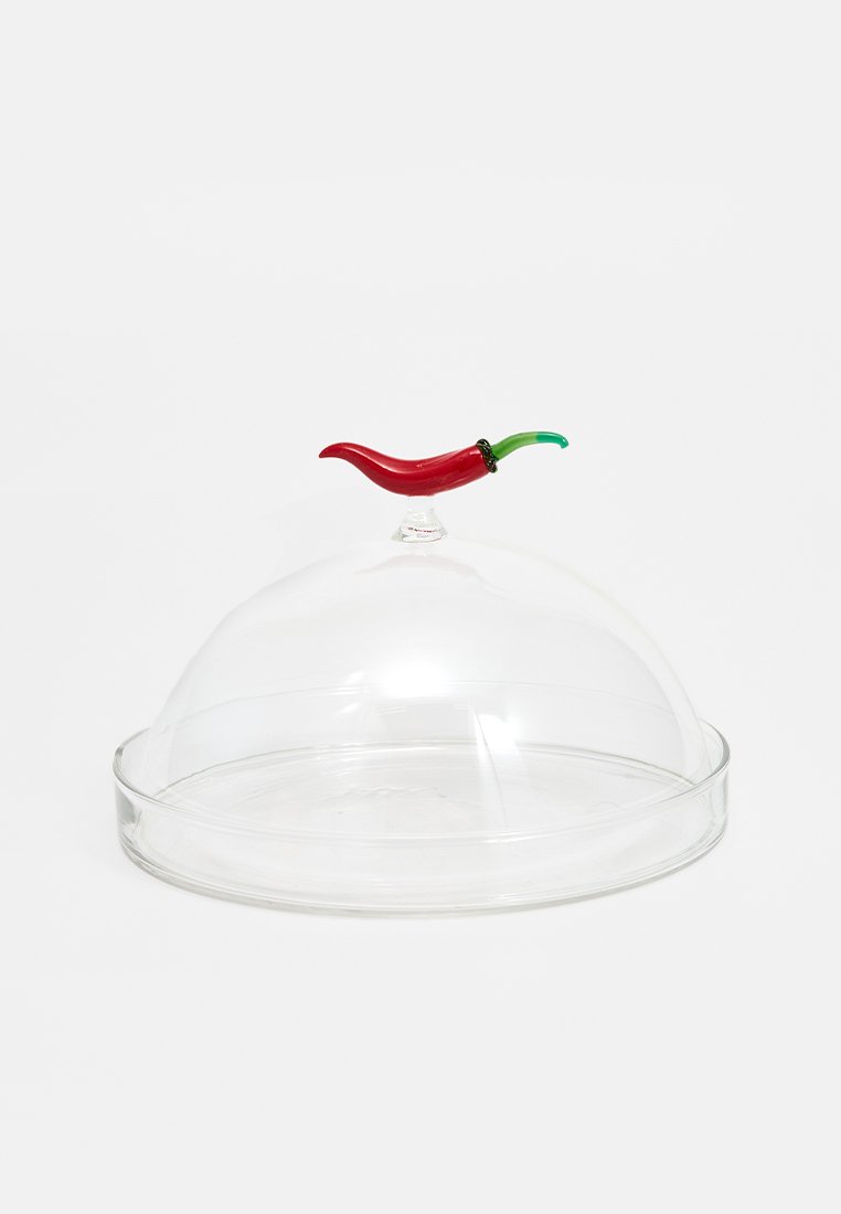 Przezroczysta szklana przykrywka w zaokrąglonym kształcie; posiada uchwyt w kształcie czerwonej papryczki oraz czarny pierścień u podstawy papryczki.