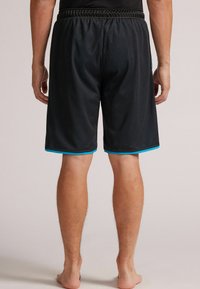 Czarne spodenki sportowe z siateczkową teksturą, z kontrastowym turkusowym wykończeniem na dole i elastyczną talią.