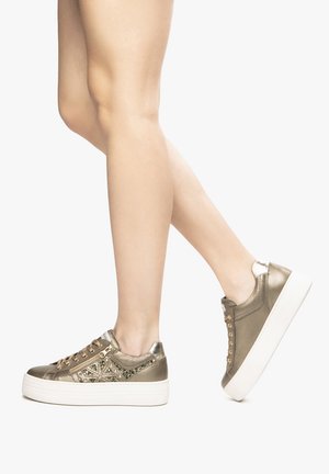 Metallic gold sneakers with a textured surface, featuring decorative studs, a white platform sole, and a zipper accent.