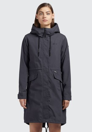 Vettävä tummanharmaa parka, jossa on huppu, vetoketjukiinnitys, säädettävä naru, kaksi etutaskua ja logo yksityiskohtana rinnassa.