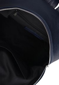 Zaino in pelle blu navy con una superficie texturizzata, chiusura con zip e un ampio interno che presenta una piccola tasca con zip e foderato in tessuto.