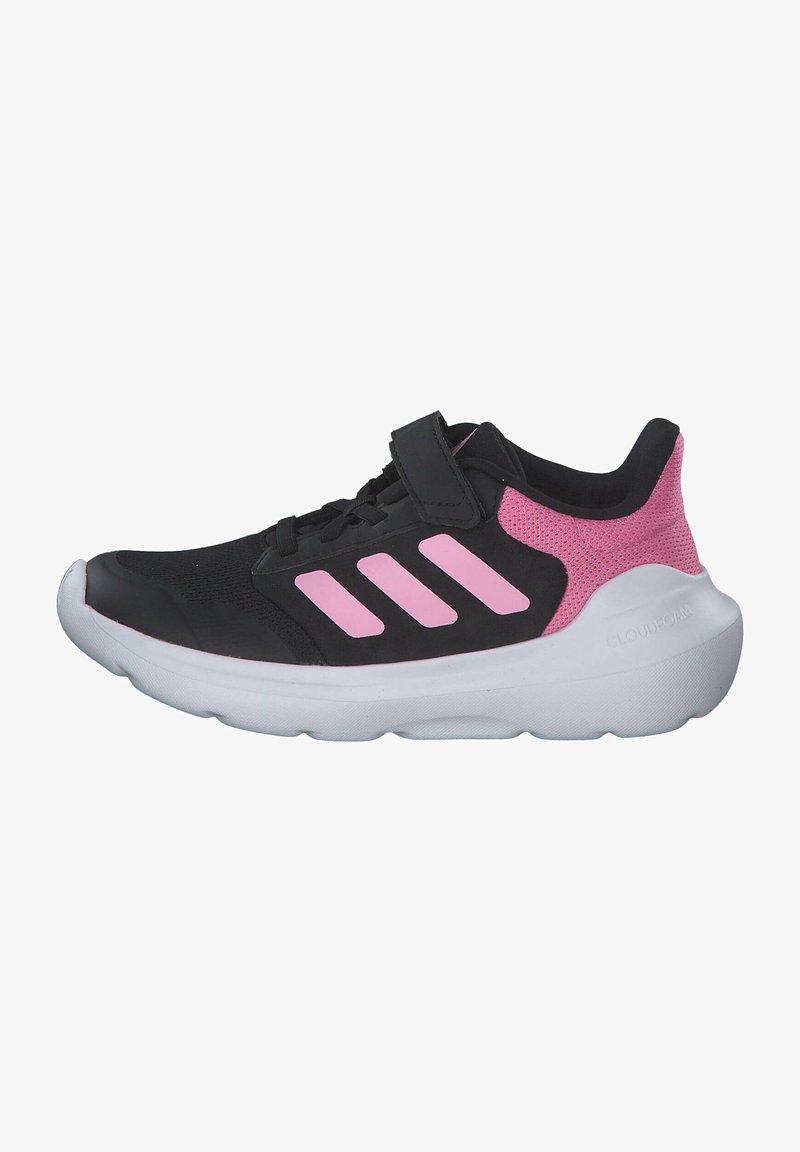 Czarno-różowy but sportowy z trzema różowymi paskami, paskiem na rzep, oddychającym materiałem na pięcie i grubą białą amortyzowaną podeszwą.