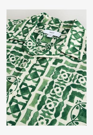 Majica s kratkimi rokavi, ki ima zeleni in bel geometrijski vzorec, narejena iz lahkega blaga, z zloženim ovratnikom in gumbnim zapenjanjem.