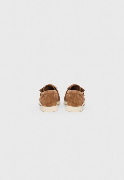 Smeđe cipele od antilopa s zaobljenim oblikom, s laganim bež gumenim potplatom i mekanim teksturama. Stražnji pogled ističe teksturirani završetak.