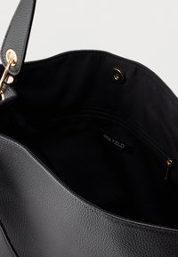 Γκρι δερμάτινη τσάντα ώμου με υφή και χρυσές μεταλλικές λεπτομέρειες, με μαύρο υφασμάτινο εσωτερικό και τσέπη με φερμουάρ. Ετικέτα με το λογότυπο της μάρκας ορατή στο εσωτερικό.