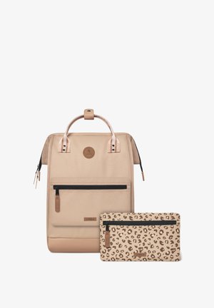 Sac à dos en tissu beige à la forme structurée, doté d'une poignée supérieure, d'une poche avant zippée et d'une pochette amovible au motif léopard.