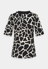 Korte mouw top met een zwart-wit girafprint, ronde halslijn met gerimpelde accenten en een zachte stoftextuur.
