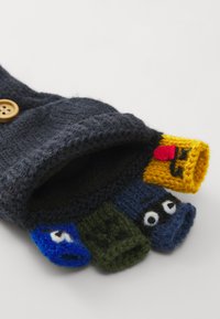 Knitted mittens in dark gray with four finger compartments in bright colors (yellow, blue, green, black) featuring playful patterns and faces.