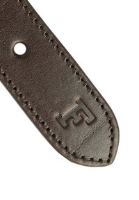 Brauner Lederarmband mit genähtem Rand und einem runden Loch. Mit geprägtem Logo-Detail. Glatte Textur mit leichtem Glanz.