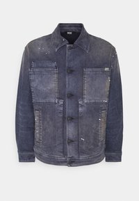 Jeansjacka i blekblått, med fyra framfickor, knäppningar med knappar och slitna detaljer. Mjuk textur med en strukturerad design.