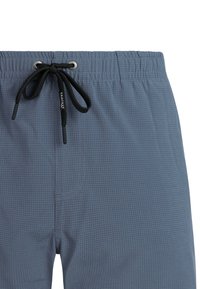 Pantalones cortos con cintura elástica azul, cordón negro atado en un lazo y un sutil patrón de cuadrícula en la tela.