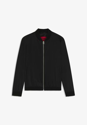 Czarna kurtka bomberka wykonana z gładkiej tkaniny, z żebrowanym kołnierzem i mankietami, przednim zamkiem błyskawicznym oraz bocznymi kieszeniami. Wewnątrz widoczne czerwone logo.