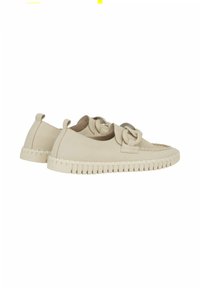 Beige instappers met een textuur van suède, voorzien van een lusvormige knoopdetail en een dikke rubberen zool met een gegroefde rand.