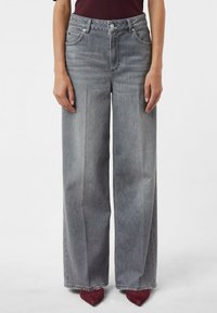 Wide-leg gray jeans made from denim, featuring a high waist, front pockets, and a smooth texture. Pairing with pointed red heels.