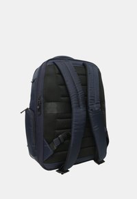 Zaino blu navy con schienale in rete nera imbottita, spallacci regolabili doppi, compartimenti con cerniera e una finitura testurizzata.