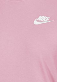 T-shirt in cotone rosa con logo Nike bianco nella parte sinistra del petto, dalla texture liscia e solida e colletto a girocollo.