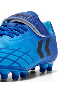 Chaussure de football bleue avec tige synthétique texturée, accents noirs et une bande velcro. Présente un design à motifs et des crampons moulés pour la traction.