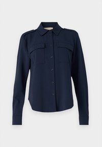 Chemise bleu marine en tissu tissé, avec des manches longues, un col, deux poches poitrine et des boutons sur le devant.