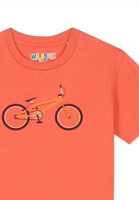 Oranje T-shirt met een grafisch ontwerp van een fiets met een felgele frame, zwarte wielen en oranje handvatten tegen een effen achtergrond.