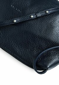 Clutch in pelle blu navy con superficie strutturata, sottile manico e due rivetti decorativi in metallo. Presenta una forma arrotondata e morbida.