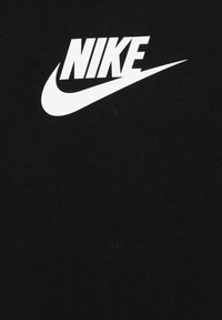Fekete szövet, középen nagy fehér Nike logóval és swoosh szimbólummal.