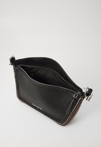 Czarna skórzana torebka kopertówka z zamkiem błyskawicznym, plecionym wykończeniem, gładką fakturą i srebrnym uchwytem zamka. Wnętrze wyłożone czarnym materiałem.