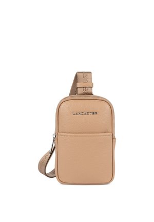 Small rectangular beige leather crossbody bag with front pocket, top zipper, and adjustable fabric strap with metal "Lancaster" logo.