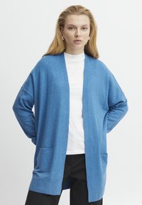 Blaues Cardigan mit lockerem Schnitt, langen Ärmeln, offener Vorderseite und zwei vorderen Taschen. Aus einem weichen, strukturierten Stoff hergestellt.