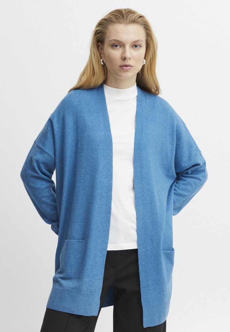 Blaues Cardigan mit lockerem Schnitt, langen Ärmeln, offener Vorderseite und zwei vorderen Taschen. Aus einem weichen, strukturierten Stoff hergestellt.