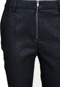 Svarta byxor med en skimrande textur, med en dragkedja fram och en skräddarsydd passform som framhäver en slank silhuett.