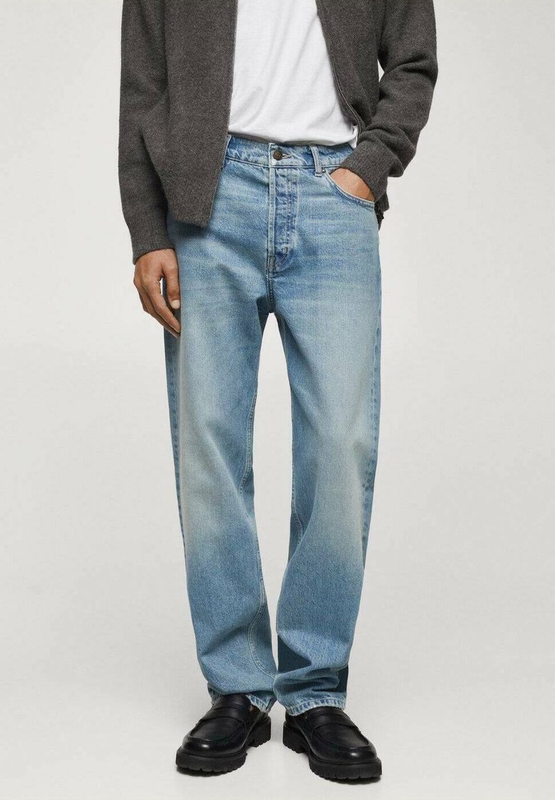 Vaaleansiniset farkut, joissa on rento istuvuus, näkyvää kulumista, viisi taskua ja napitus. Yhdistetty tummanharmaaseen vetoketjulliseen takkiin.