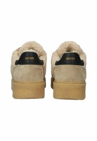 Tan suede shoes featuring a fluffy beige collar and black heel tab with embossed logo. Textured gum sole for grip. Rear view displayed.
