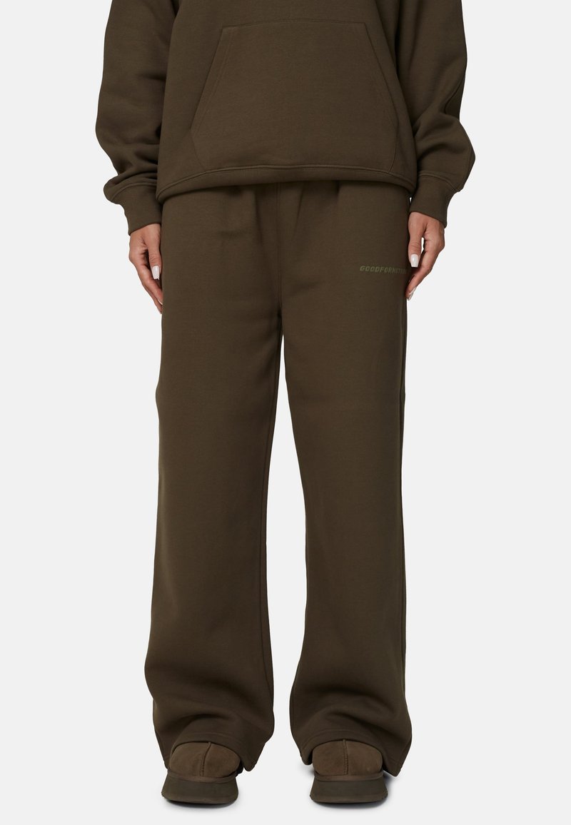 Sweatshirt marron et pantalon de survêtement assorti avec une coupe décontractée. Comprend une poche kangourou et un logo discret sur la jambe gauche. Texture lisse.