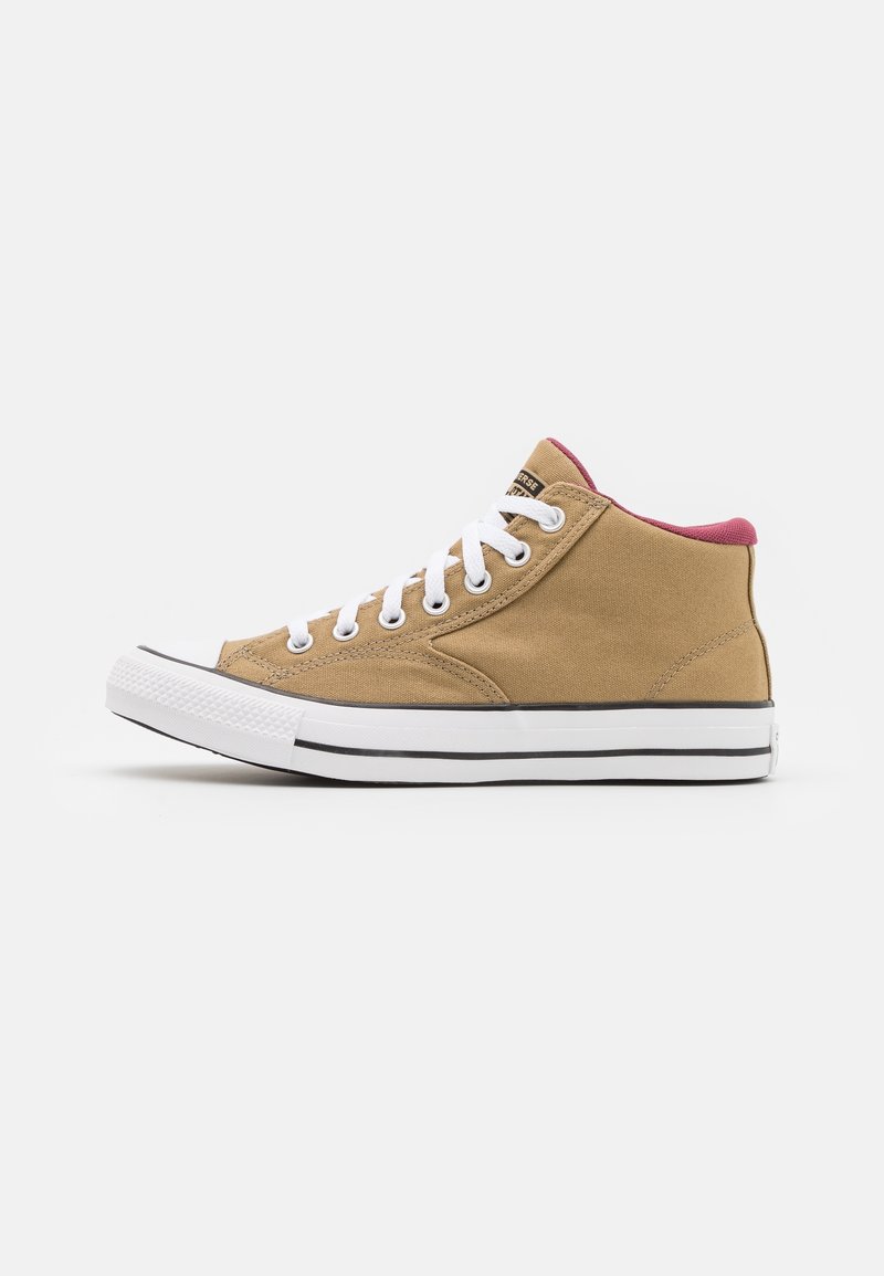 Tan canvas högstövel sneakers med vita snören, en rosa krage och en svart sula. Har en rund tå och texturerad yta.