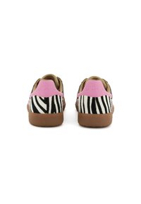 Un paio di sneakers con strisce zebra, linguette rosa sul tallone e suole marroni, viste da dietro su uno sfondo bianco.