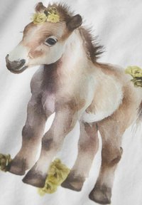 Akvarellillustration af et føl med en brun og hvid pels, pryget med gule blomster i manken og tæt på fødderne. Hvid baggrund.