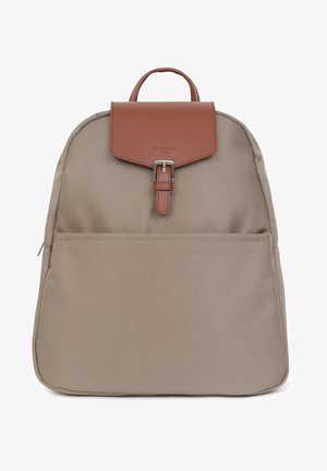 Sac à dos en tissu beige avec un rabat en cuir marron, une boucle en argent, une poche zippée à l'avant et une poignée sur le dessus. Texture lisse et design minimaliste.