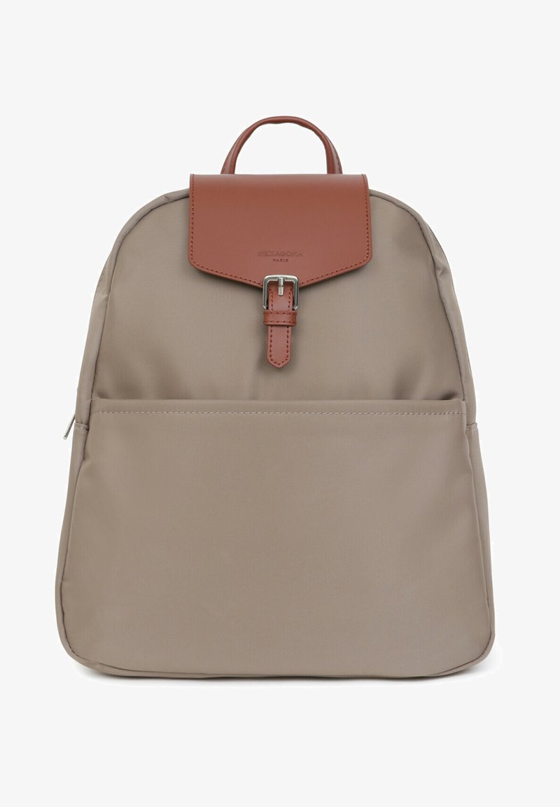 Beige stoffen rugzak met een bruine leren klep, zilveren gesp, voorzak met rits en handvat bovenaan. Gladde textuur en minimalistisch ontwerp.