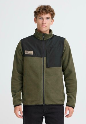Fleece jacket in dark green with a black upper panel and chest pocket. Features a high collar and front zipper. Textured, soft finish.