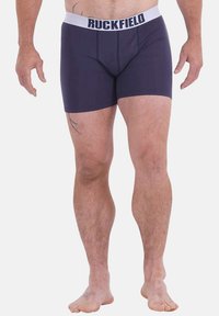 Boxer-briefs marine en tissu extensible avec une taille élastique blanche affichant le logo "RUCKFIELD". Design ajusté avec une texture lisse.