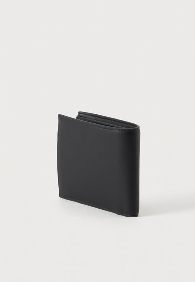 Portefeuille bifold noir en cuir fermé sur une surface blanche avec des coutures visibles le long des bords.