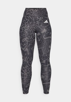 Schwarze Leggings mit einem strukturierten, abstrakten Muster in Grautönen, ausgestattet mit einem hohen Bund und einem weißen Logo an der Hüfte.