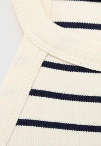 Cream fabric with navy horizontal stripes, featuring textured ribbing and smooth edges. A close-up view highlights stitching details.