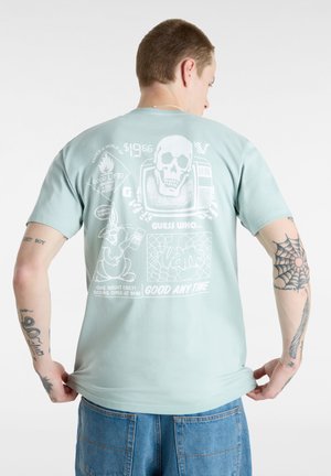 Myntgrøn bomulds t-shirt. Grafisk design på ryggen inkluderer et kranium, et fjernsyn og en tegneseriekanin. Korte ærmer, afslappet pasform, rund hals.
