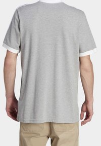 Graues Kurzarm-T-Shirt mit weißem Kragen und Akzenten an den Ärmeln. Weicher Stoff, lässige Passform und schlichtes Design, geeignet für Freizeitkleidung.